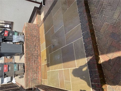 Paving and a step beside a low brick wall
