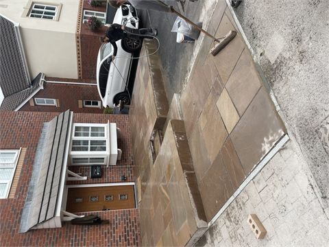 Paved driveway and house entrance with a parked car