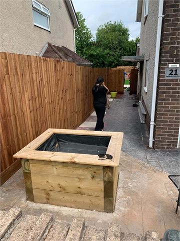 Timber boundary fence and raised planter beside a path