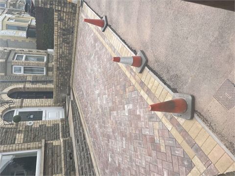 Block-paved frontage beside entrance steps and traffic cones