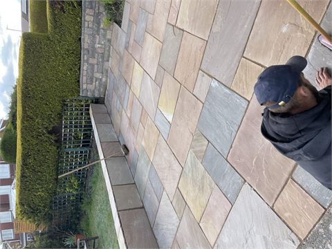 Multicoloured patio paving beside raised garden beds