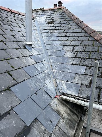 Sloping roof covering with pipe flashing and guttering