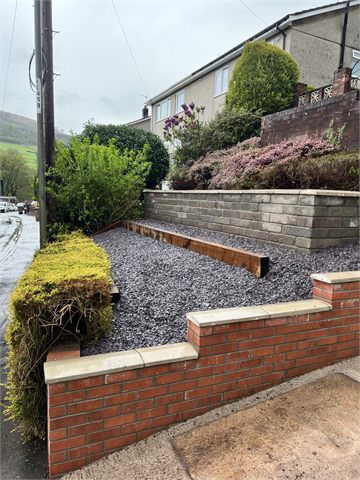 Terraced garden beds with retaining walls, steps and gravel