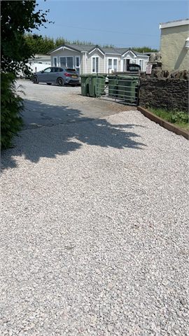Gravelled driveway extending towards neighbouring houses