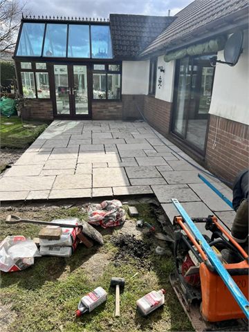 Paving work and tools beside a conservatory